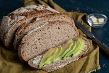 freshly baked country bread sliced with butter and avocado