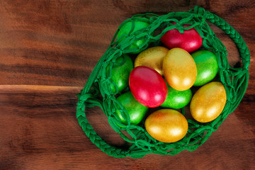 Bright, beautiful multi-colored Easter eggs in a vintage purse on a wooden background. Easter ideas.Copy the space for the text. Minimalism. Background with Easter eggs. Flat lay