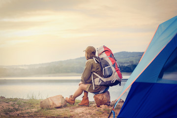 Woman backpack See the sunset by the swamp / camping / romantic atmosphere. Relaxing time camping on a mountain. Activity in holiday and hiking concept.