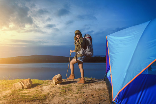 Woman carrying backpack at dusk / camping / romantic atmosphere. Relaxing time camping on a mountain. Activity in holiday and hiking concept. Add filter film grain.