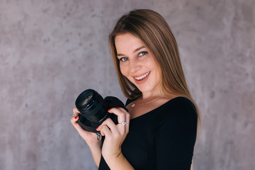 Beautiful female photographer smiling and posing with camera dsl