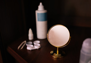 Case for contact lenses for the eyes with mirror, bottle, tweezers and eye drops