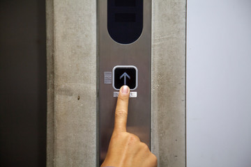 エレベーターボタンを押す指