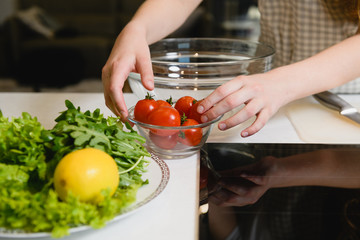 Female hands with salad ingredients on table