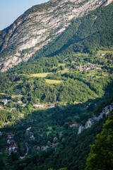 Naklejka na ściany i meble Small houses nestled on a lush green hillside in the french alps in Grenoble France