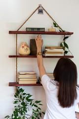 close up photo of female hand wearing yellow wrist watch  with roman numerals and trying to reach...