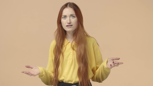 What happening. Confused and puzzled redhead woman with long natural ginger hair, spread hands sideways, look questioned and clueless, cand understand, dont know, asking question