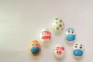 Easter eggs in a basket on a white background with the inscription sit at home