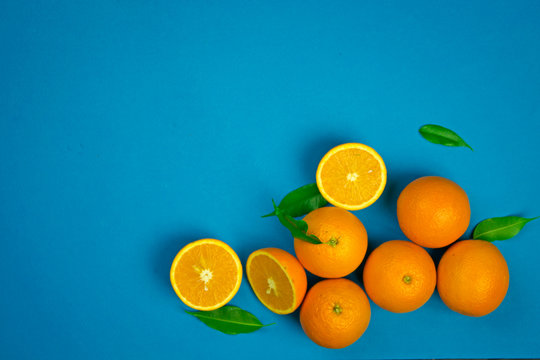 orange vibrant oranges laid out on a blue background with place for text top view, citrus vitamin fruits, organic healthy food © Victoriia
