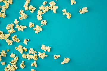 popcorn sprinkled on a blue background, place for text, concept of relaxing and spending free time, watching movies
