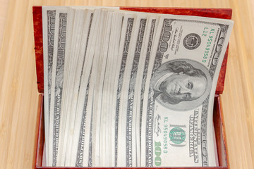 American hundred dollar bills in large quantities in a wooden box