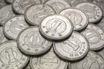 Field of Japanese coins at 1 yen close-up. Illustration with aged effect. News about the economy, finance and interest rate of the central bank of Japan. External and public debt, deflation. Macro