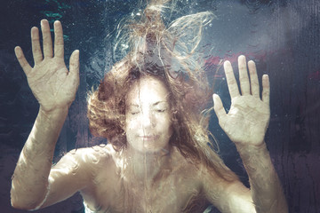 Woman under water. A young woman is trapped in a water surface. Hands resting on. summer feeling....