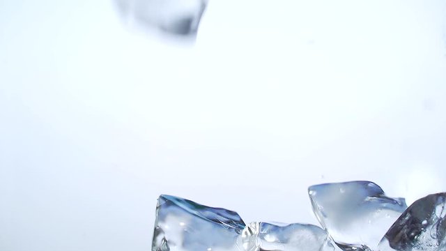 ice cubes falling from a glass on a white background. close up. slow motion. Close-up. macro. pieces of ice fill the glass container. Ice in different pieces. Abstract. making a cool drink making