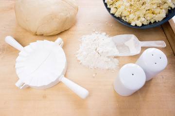 National Russian cuisine. Pierogi or pyrohy, vareniki, served with cottage cheese and potatoes on board.  Raw dumplings made of dough in handmade flour