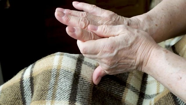 Close-up of an old female hands in the prosess of self-massage