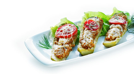 Stuffed zucchini boats filled with a sausage mixture topped with cheese. Ketogenic low-carb meal.