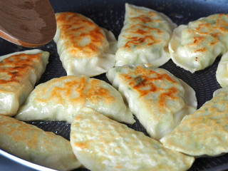 Dumplings are fried in a pan. Asian dish with a variety of fillings. Fried Gyoza