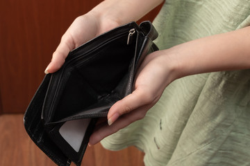 Empty wallet without money in female hands