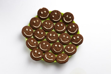 Chocolate cookies with smilies in top.