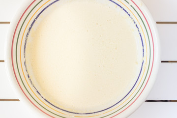 Bowl with beaten eggs milk flour for cooking pancakes - 340400116