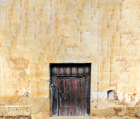Fototapeta na wymiar Wooden door in a stone wall