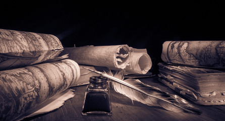 Quill pen, inkwell and old rolled up maps and papers, sepia effect - 340400910