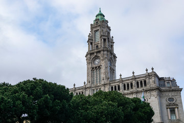 Fototapeta na wymiar Porto City Hall. Pine trees. Blue sky with clouds.