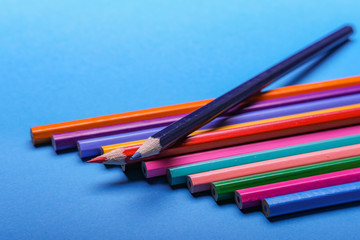 Color pencils of various color on a blu background