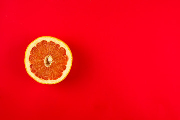 half of grapefruit on a red bright background with place for text, citrus fruits, vitamins and good