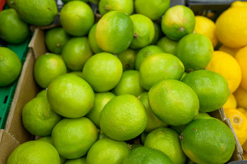 yellow and green lemons on the shelves in the supermarket for buyers, citrus