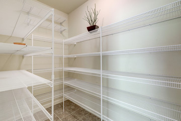 Empty large pantry interior with lots of shelves. - obrazy, fototapety, plakaty