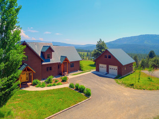 Fototapeta na wymiar Amazing beautiful mountain home in Cascade Mountains in USA with green lavish maountains, cedar large home.
