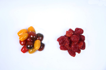 a pile of dried tomatoes and cherry-tomatoes isolated on white background flat lay. Horizontal image.