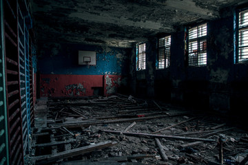 View of the ruined gym with a basketball hoop and light from a window at a school in Teriberka. Like after the war. Apocalypse. © Алексей Васильев