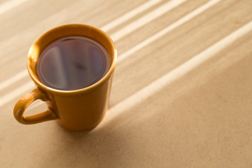 A cup of coffee or tea on the wooden background.