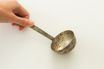 The old silver color copper ladle on the white background.