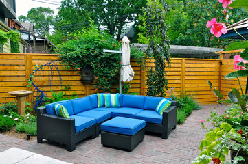 Relaxing patio furniture is seen in a beautiful urban backyard garden.