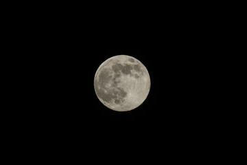 Full moon over dark black sky at night,