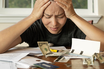 Woman looking at her financial bills stressed out; No money/bankruptcy