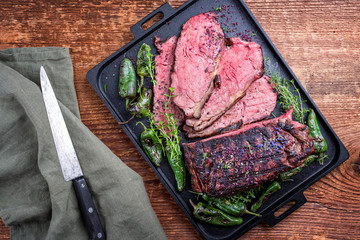 Traditional Commonwealth Sunday roast with sliced cold cuts roast beef with herbs and chili as top...