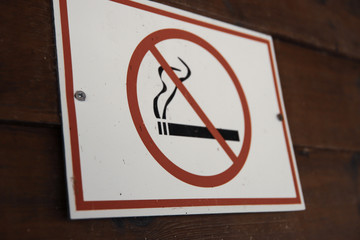 No smoking sign at the wooden wall. A no smoking sign in a place is a notice to say that smoking is...