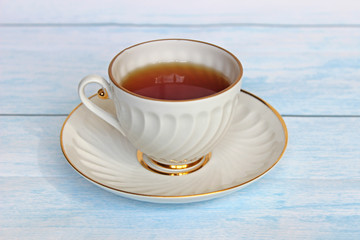 Top view of a cup of tea with tea bag on blue wooden table