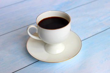 Cup of fresh coffee on blue wooden background, top