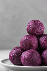 Energy balls made of blueberries, acai, dates and nuts. Healthy vegan food dessert. vertical orientation