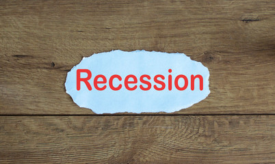 Word recession on the piece of paper. Wood table.