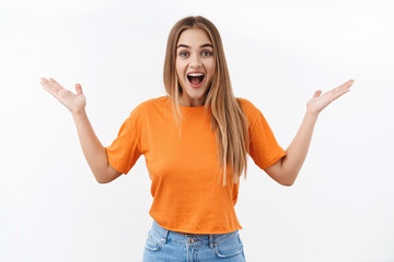 What wonderful news. Portrait of enthusiastic blond girl express overjoy and surprised, spread hands sideways and smiling amused, hear amazing info, react to lucky amazing situation, white background