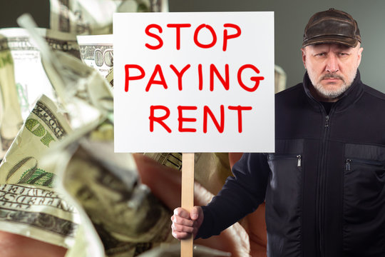 A man with a placard calling to stop paying rent. A protester against the background of crumpled dollars. The businessman demands to review the lease payments for the time of quarantine.