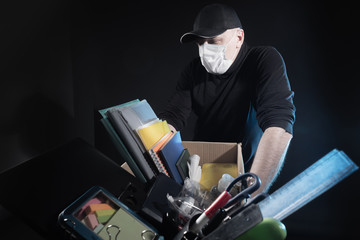 The despair of losing your job. The masked man leans against a box of office supplies. The man doesn't know what to do next. Unemployment. Lack of jobs. Crisis. Bankruptcy.