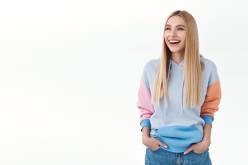 Portrait of carefree, good-looking blonde caucasian girl laughing at something hilarious, looking...